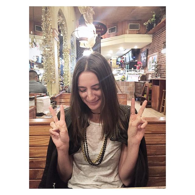 Lauren Deleo in a white t-shirt and black jacket posing at a hotel.